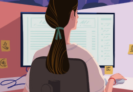 A person seen from behind sitting at a desk and looking at a computer monitor displaying a Slack interface.